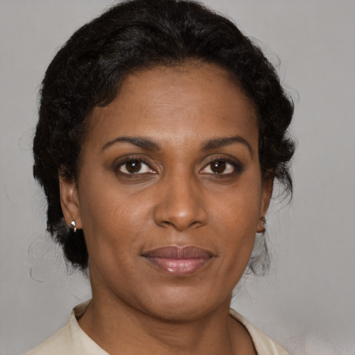 Joyful black adult female with medium  brown hair and brown eyes
