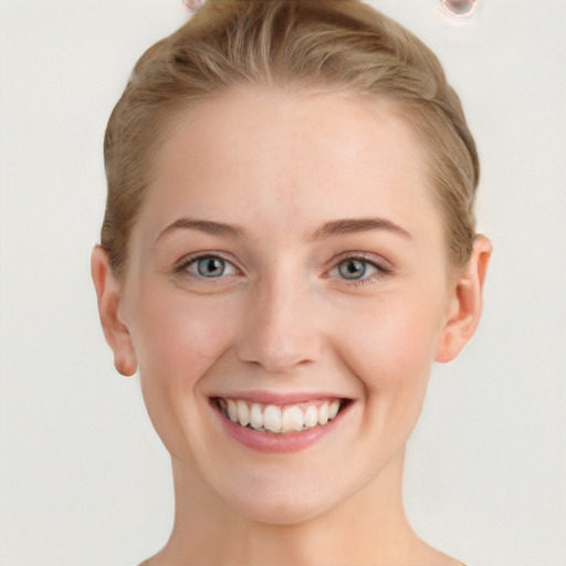 Joyful white young-adult female with short  brown hair and blue eyes