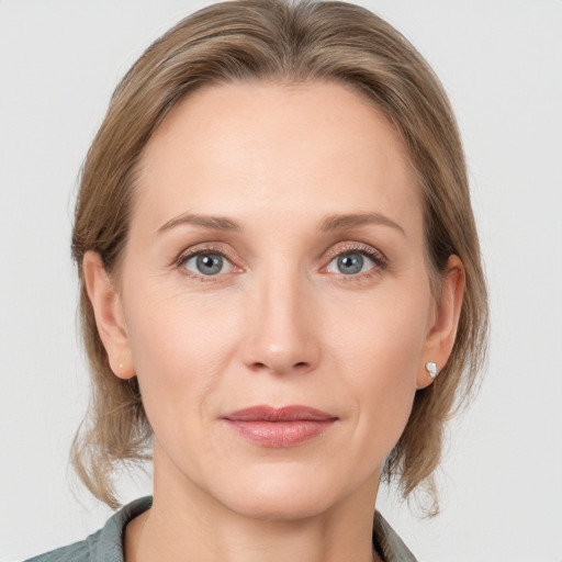 Joyful white adult female with medium  brown hair and grey eyes