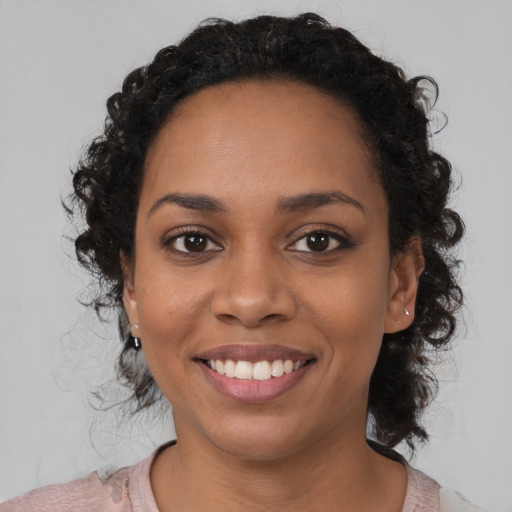 Joyful black young-adult female with medium  black hair and brown eyes