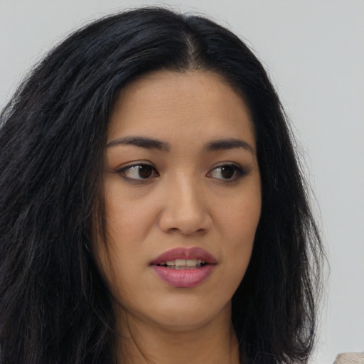 Joyful latino young-adult female with long  brown hair and brown eyes
