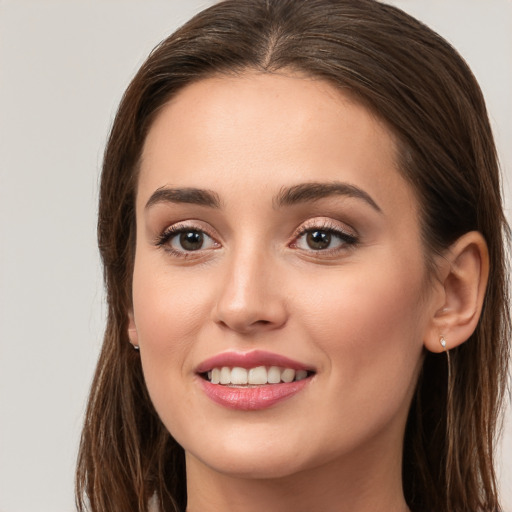 Joyful white young-adult female with long  brown hair and brown eyes