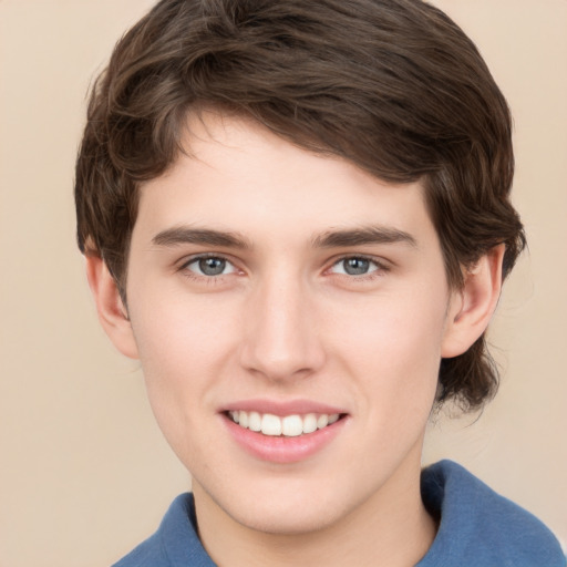 Joyful white young-adult male with medium  brown hair and grey eyes