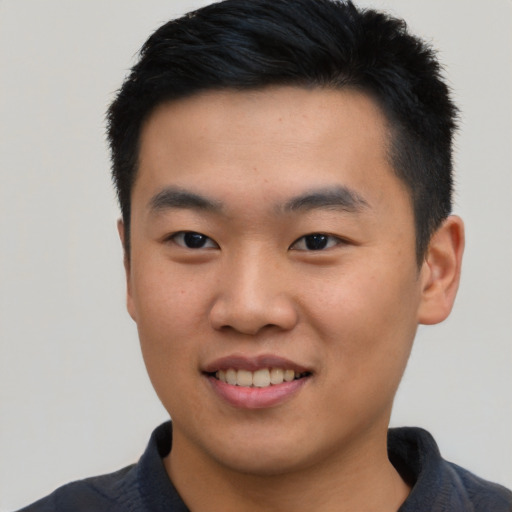 Joyful asian young-adult male with short  black hair and brown eyes