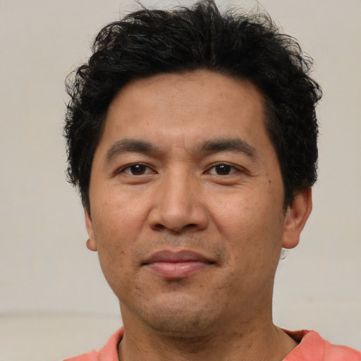 Joyful asian adult male with short  brown hair and brown eyes