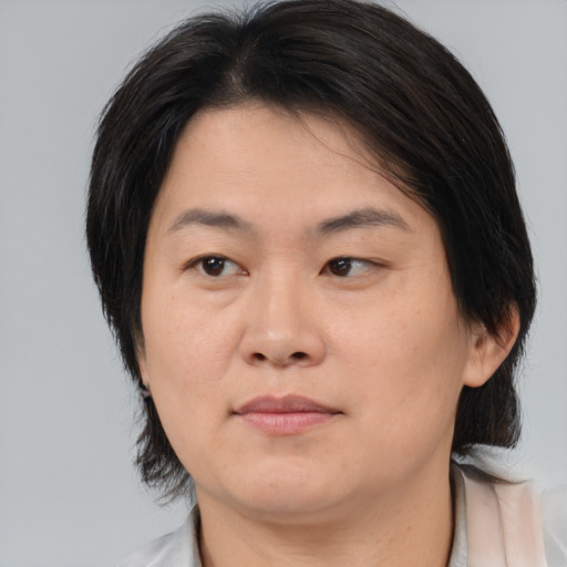 Neutral asian adult female with medium  brown hair and brown eyes