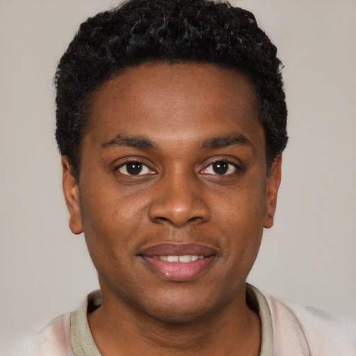 Joyful black young-adult male with short  black hair and brown eyes
