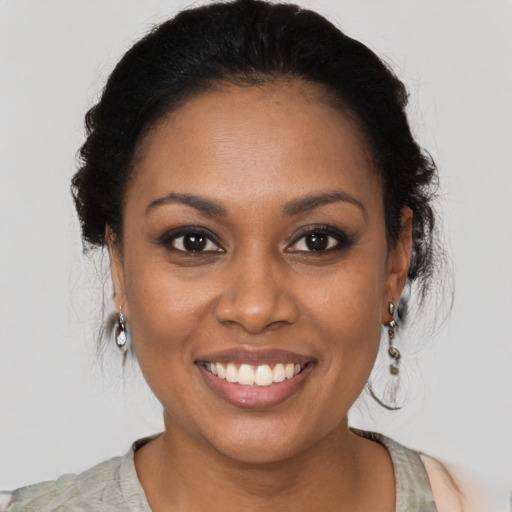 Joyful black young-adult female with medium  brown hair and brown eyes