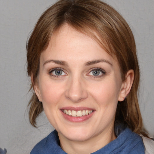 Joyful white young-adult female with medium  brown hair and blue eyes