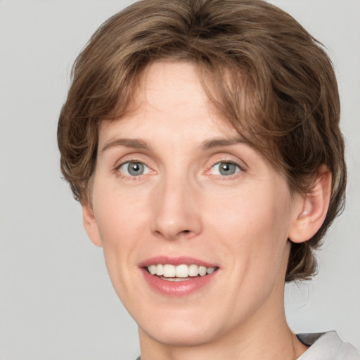 Joyful white young-adult female with medium  brown hair and green eyes