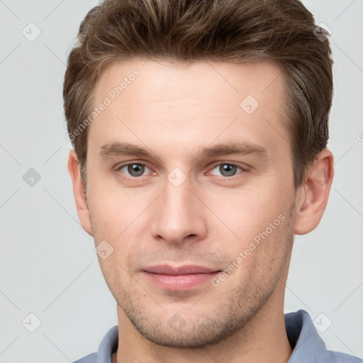 Joyful white young-adult male with short  brown hair and grey eyes