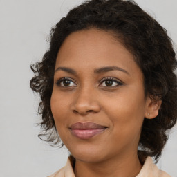 Joyful black young-adult female with medium  brown hair and brown eyes