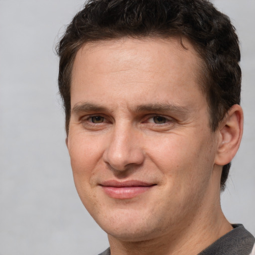 Joyful white young-adult male with short  brown hair and brown eyes