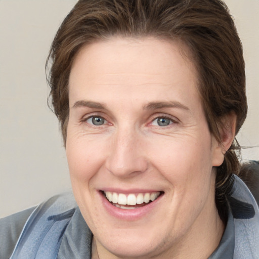 Joyful white adult female with medium  brown hair and grey eyes