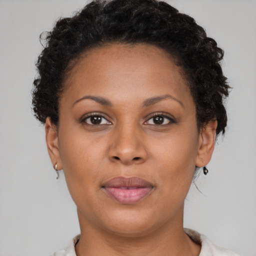 Joyful black young-adult female with short  brown hair and brown eyes