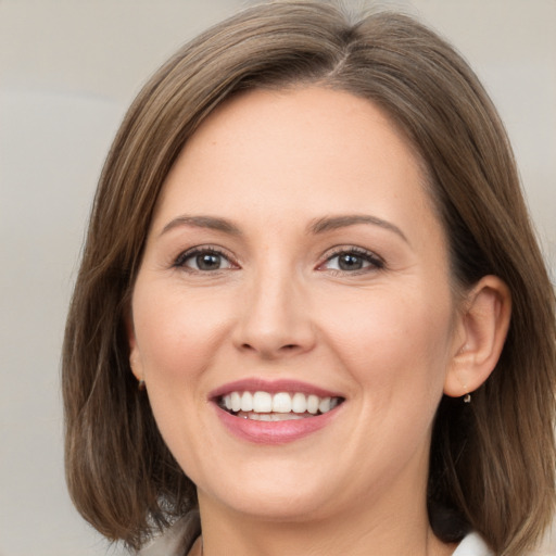 Joyful white young-adult female with medium  brown hair and grey eyes