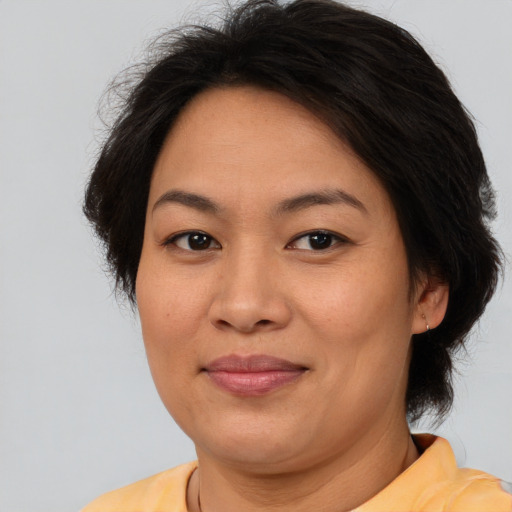 Joyful asian adult female with medium  brown hair and brown eyes