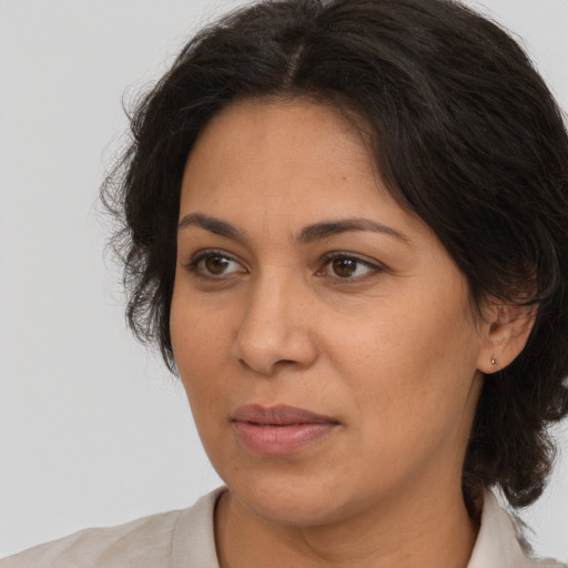 Joyful latino adult female with medium  brown hair and brown eyes
