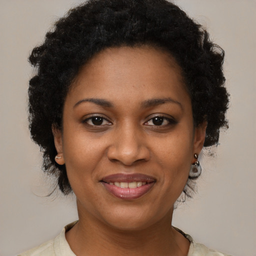 Joyful black young-adult female with medium  brown hair and brown eyes