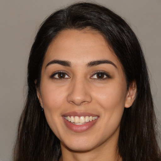 Joyful latino young-adult female with long  brown hair and brown eyes