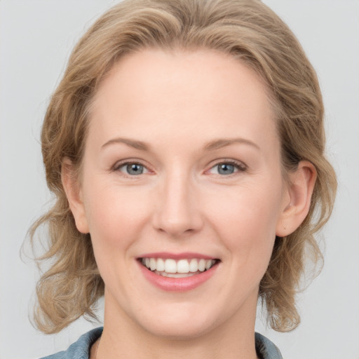 Joyful white young-adult female with medium  brown hair and blue eyes