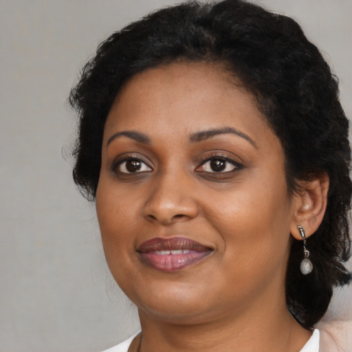 Joyful black adult female with medium  black hair and brown eyes