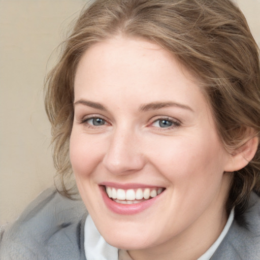 Joyful white young-adult female with medium  brown hair and blue eyes