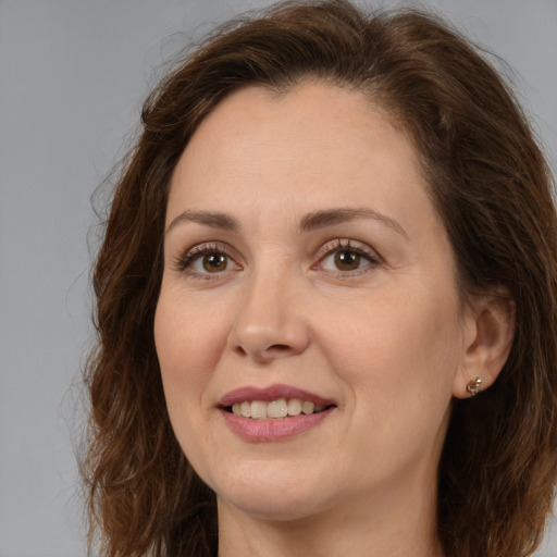 Joyful white adult female with long  brown hair and brown eyes