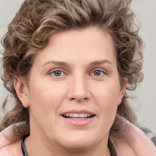 Joyful white young-adult female with medium  brown hair and blue eyes