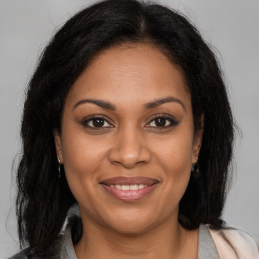Joyful black young-adult female with long  brown hair and brown eyes