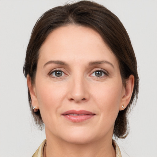 Joyful white adult female with medium  brown hair and grey eyes