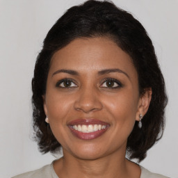 Joyful black adult female with medium  brown hair and brown eyes