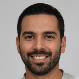 Joyful white young-adult male with short  black hair and brown eyes