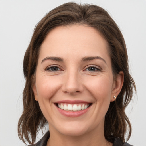 Joyful white young-adult female with medium  brown hair and grey eyes