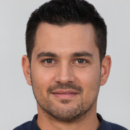 Joyful white young-adult male with short  brown hair and brown eyes