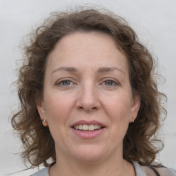 Joyful white adult female with medium  brown hair and grey eyes