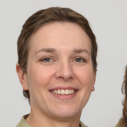 Joyful white adult female with medium  brown hair and grey eyes