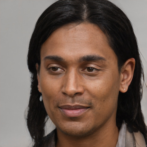Joyful latino young-adult male with long  black hair and brown eyes