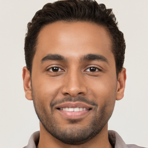 Joyful latino young-adult male with short  brown hair and brown eyes