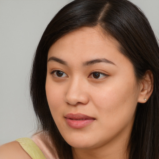 Joyful asian young-adult female with long  brown hair and brown eyes