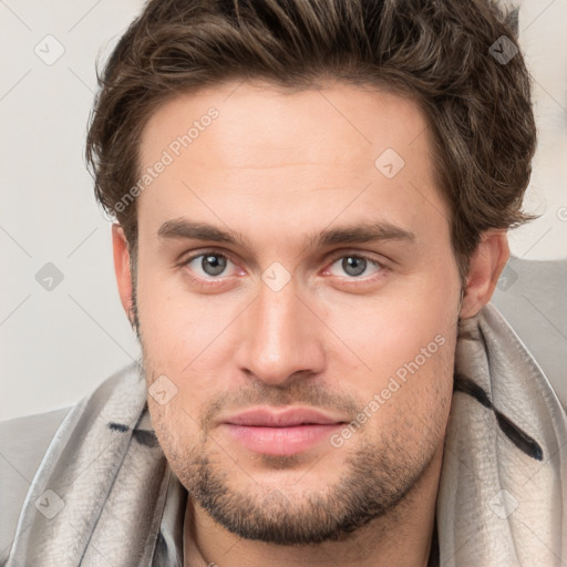 Joyful white young-adult male with short  brown hair and grey eyes