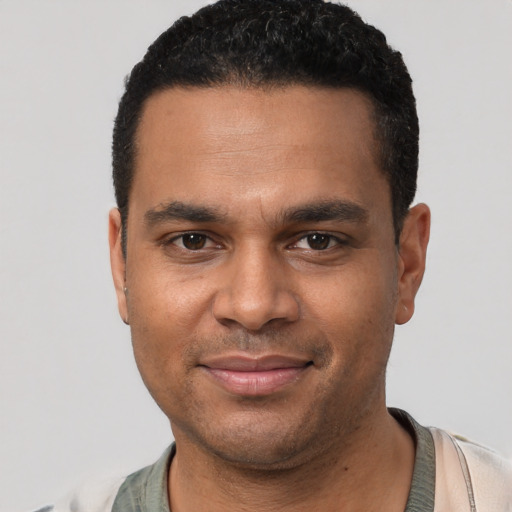 Joyful black young-adult male with short  black hair and brown eyes