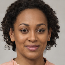 Joyful black adult female with medium  brown hair and brown eyes