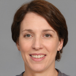 Joyful white adult female with medium  brown hair and grey eyes