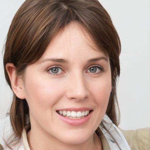 Joyful white young-adult female with medium  brown hair and grey eyes