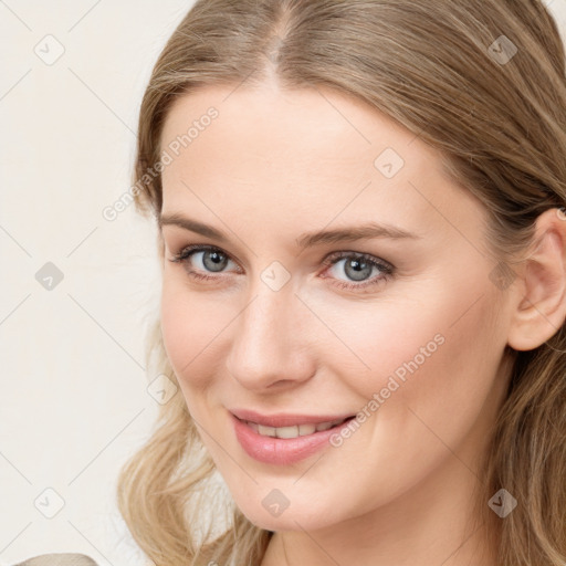 Joyful white young-adult female with long  brown hair and blue eyes