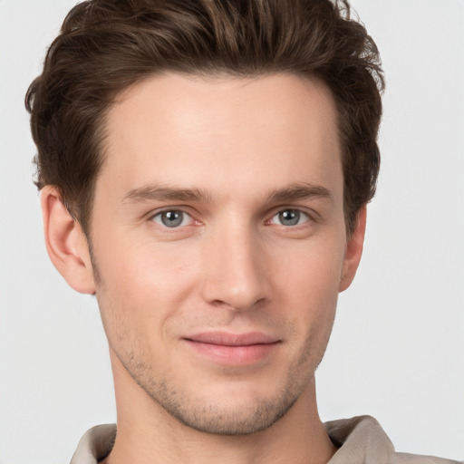 Joyful white young-adult male with short  brown hair and grey eyes