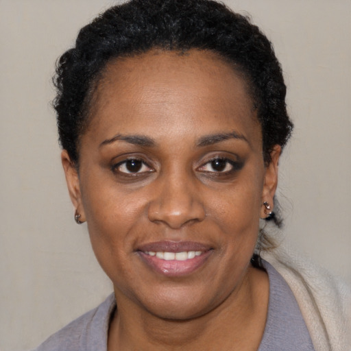 Joyful black young-adult female with short  black hair and brown eyes