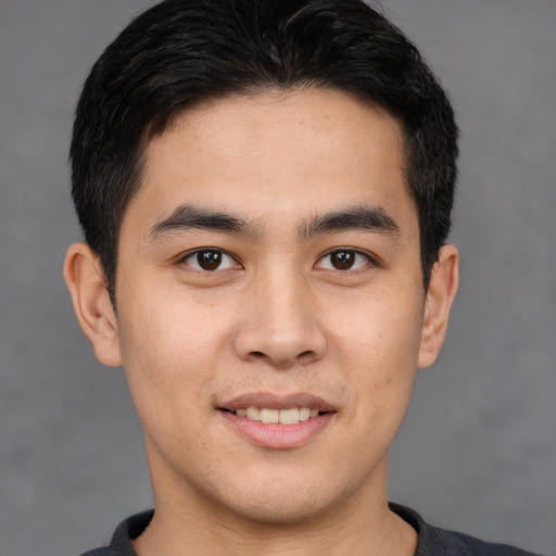 Joyful latino young-adult male with short  brown hair and brown eyes