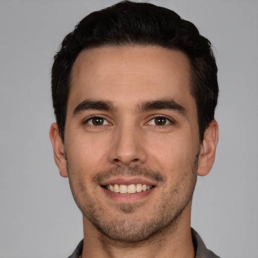 Joyful white young-adult male with short  black hair and brown eyes